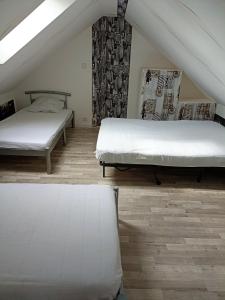 two beds in a room with wooden floors at Appartement de 2 chambres avec terrasse amenagee et wifi a Arnage in Arnage