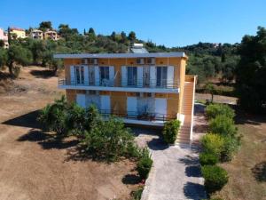 a yellow house on top of a field at Pagonia Apartments in Arillas