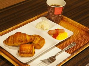 a tray with a plate of pastries and a cup of coffee at HOTEL LiVEMAX PREMIUM Himejieki-Minami in Himeji