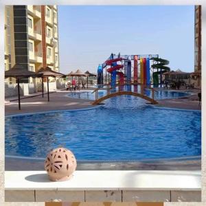 un parque infantil con un tobogán de agua en una piscina en استوديو للعائلات داخل قرية Retal View north coast, en El Alamein
