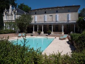 uma casa grande com uma piscina em frente em Château Fleur D'Aya em Artigues-près-Bordeaux