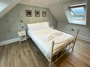 um quarto com uma cama com lençóis brancos e uma janela em Pass the Keys Beautifully Presented 3BR Luxury Apartment em Kirkcudbright