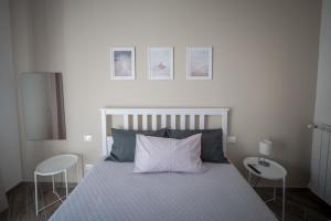Ein Schlafzimmer mit einem Bett, zwei Stühlen und zwei Bildern an der Wand in der Unterkunft Saint Joseph in Livorno