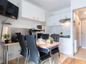 eine Küche mit einem Tisch und Stühlen im Zimmer in der Unterkunft Studio Vielle-Aure, 1 pièce, 4 personnes - FR-1-296-389 in Vielle-Aure