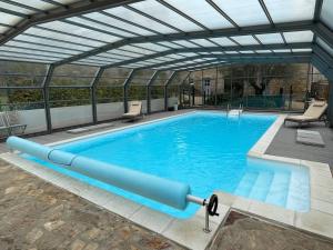uma grande piscina com telhado de vidro em Maison Louannec, 3 pièces, 5 personnes - FR-1-368-343 em Louannec