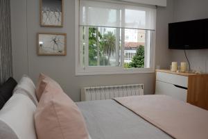 a bedroom with a bed with a window and a television at Oliva Suite in Pontevedra