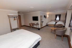 a hotel room with two beds and a desk at Boundary, Alfreton by Marston's Inns in Alfreton