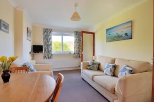a living room with a couch and a table at Bridge House Apartment in Charmouth