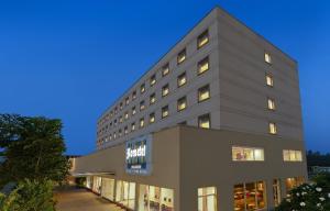 a large gray building with many windows at Hometel Roorkee in Roorkee