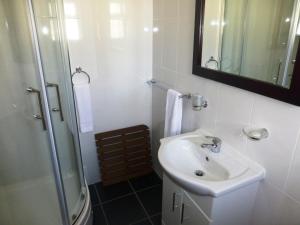 een witte badkamer met een wastafel en een douche bij Esplanade Hotel - Clacton On Sea, Beachfront Hotel by OYO in Clacton-on-Sea +28 foto's