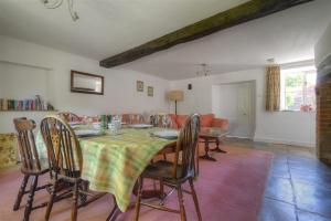 een eetkamer met een tafel en stoelen bij Trill Cottage in Musbury
