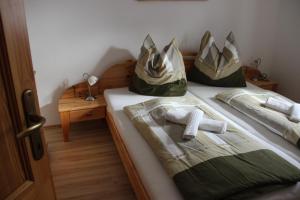 1 Schlafzimmer mit 2 Betten mit Handtüchern und Taschen in der Unterkunft Groppenstein Apartmanház in Obervellach