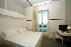 a bedroom with a bed and a desk and a window at Hotel Piccolo Portofino in Portofino
