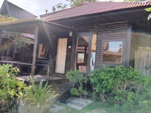 a wooden house with a porch and some plants at Tommy Resort in Haad Rin