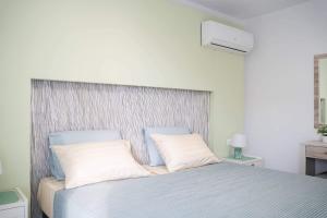 een slaapkamer met een bed met 2 witte kussens bij LambiSea Apartment 2 in Kos-stad