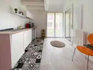 uma cozinha com armários brancos e piso em azulejo preto e branco em LE COCON D'AUTEUIL - ICI CONCIERGERIE em Auteuil