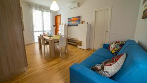 - un salon avec un canapé bleu et une table dans l'établissement Le Case del Porticciolo, à Isola delle Femmine