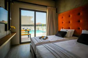 a bedroom with two beds and a view of a pool at Old Cinema Suites in Laganas