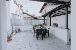 patio ze stołem i krzesłami na balkonie w obiekcie Appartamento Picche w mieście Peveragno