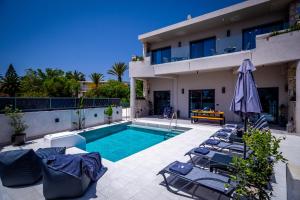 a villa with a swimming pool and a house at Old Cinema Suites in Laganas
