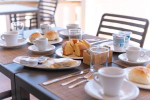 un tavolo con piatti di pane e tazze di caffè di Il Pappagallo a Leuca