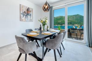 a dining room with a table and chairs and a large window at Amazing Sea View Apartments Petra & Paula in Slano