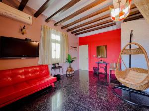 een woonkamer met een rode bank en een flatscreen-tv bij Early Summer in Huxi