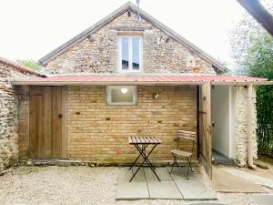 a brick shed with a table and two chairs at LE COCON D'AUTEUIL - ICI CONCIERGERIE in Auteuil