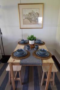 una mesa de madera con cuencos azules y platos en ella en Cozy and peaceful cabin 15 mins from Lyme Regis, en Bridport