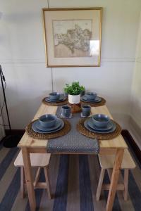 a wooden table with blue bowls and plates on it at Cozy and peaceful cabin 15 mins from Lyme Regis in Bridport