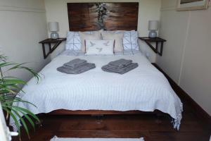 Un dormitorio con una cama con dos toallas encima. en Cozy and peaceful cabin 15 mins from Lyme Regis, en Bridport