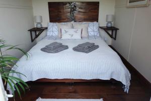 a bedroom with a bed with two towels on it at Cozy and peaceful cabin 15 mins from Lyme Regis in Bridport