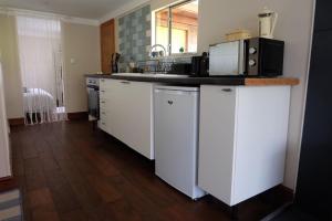 Una cocina con gabinetes blancos y encimera. en Cozy and peaceful cabin 15 mins from Lyme Regis, en Bridport