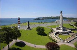 a park with a monument and a lighthouse and the ocean at Quay33 Deluxe Apartment, Barbican, Plymouth in Plymouth