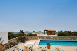 a villa with a swimming pool and a table and chairs at Plaka Modern Apartment in Chania Town