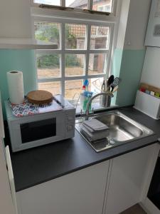 a kitchen counter with a microwave and a sink at Beachside - North Berwick in North Berwick