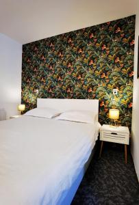 布拉索夫Coroni studio with jacuzzi的卧室配有白色床和花卉壁纸