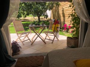 - une table et deux chaises sur la terrasse dans l'établissement LA MAISON DE LA DUNE - Jacuzzi 1ère séance offerte - Piscine chauffée avec Abri Amovible - Plage située à 200m, accès direct par le bois, à La Couarde-sur-Mer