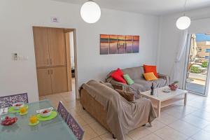 un soggiorno con divano e tavolo di Mythical Sands Resort & Spa, Evilion Apartment a Paralimni