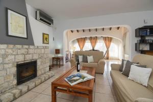 a living room with a fireplace and a couch at Villa Dulce Cala Baladrar in Benissa