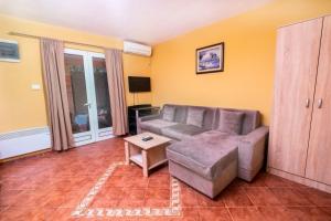 uma sala de estar com um sofá e uma mesa em APARTMANI VUKADINOVIC LUX em Budva mais 3 fotografias