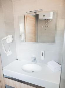 W białej łazience znajduje się umywalka i lustro. w obiekcie FoRest Međugorje w Medziugorie