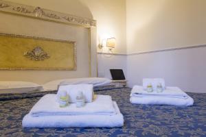 a hotel room with two beds with towels at Relais Tiffany in Florence