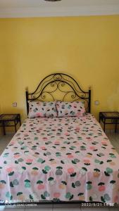 1 Schlafzimmer mit einem Bett mit Blumenbettdecke in der Unterkunft Riad Alaoui 146 with swimming pool and free parking in Marrakesch