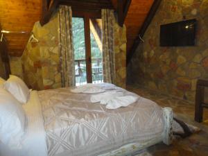 a bed in a room with a stone wall at eco oneiro resort in Kalavrita