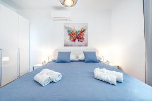 a bedroom with a blue bed with two pillows at Amazing Sea View Apartments Petra & Paula in Slano