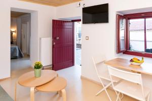 een keuken en eetkamer met een rode deur en een tafel en stoelen bij Mariloo’s Apartment in Nafplio