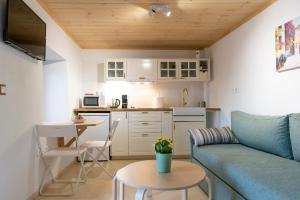 een keuken en een woonkamer met een bank en een tafel bij Mariloo’s Apartment in Nafplio