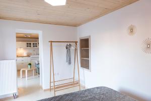 een slaapkamer met witte muren en een houten plafond bij Mariloo’s Apartment in Nafplio