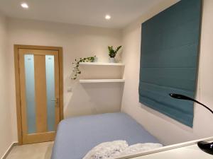 a small room with a blue bed and a door at Mosta Garden Studio in Mosta